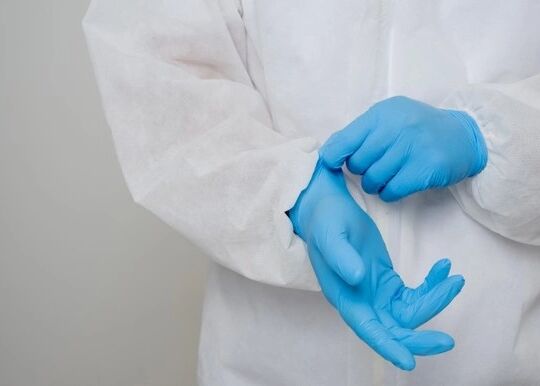 close-up-portrait-virologist-put-ppe-suit-checking-blue-glove-his-hand_208349-218